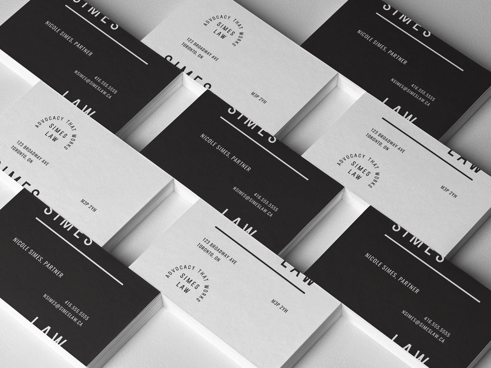 Image of black and white business cards for Simes Law in Toronto