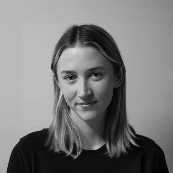 Black and white portrait of a young woman with shoulder-length hair, wearing a dark top, looking at the camera with a slight smile. Haven Lyon project manager at Sidfactor