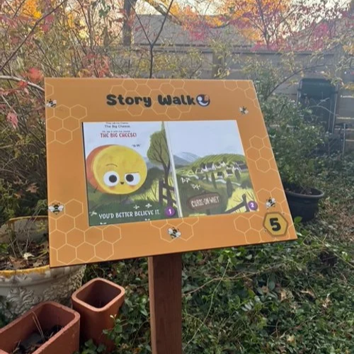 Plymouth Public Library StoryWalk Sign with bees and honeycomb features