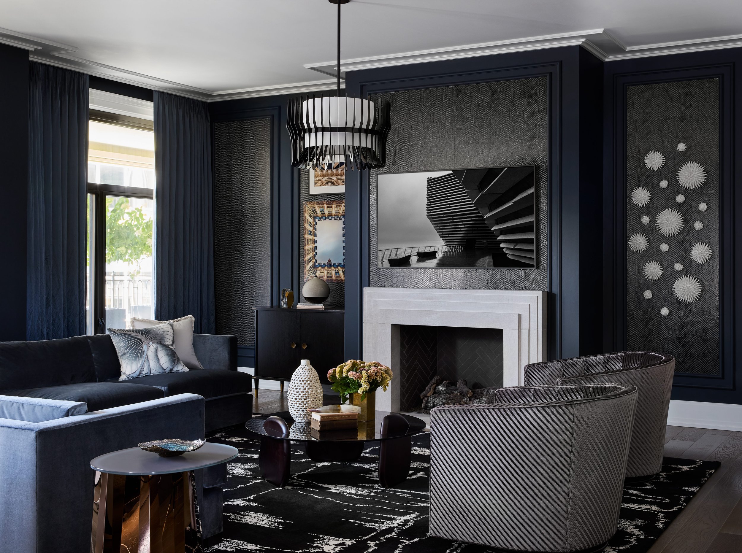 Sophisticated Chicago condo living room with layered textures, custom seating, statement lighting, and contemporary artwork. A Moody color palette with a fireplace, designed by a luxury interior design firm based in Chicago and Denver.