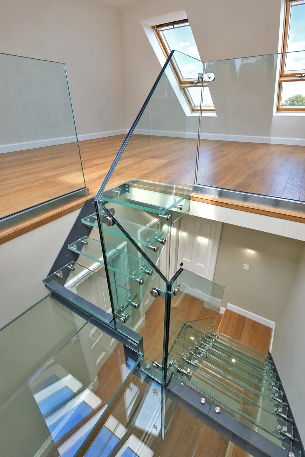 Overhead view of the glass staircase, glazed landings and open loft floor in a Newport-on-Tay conversion.