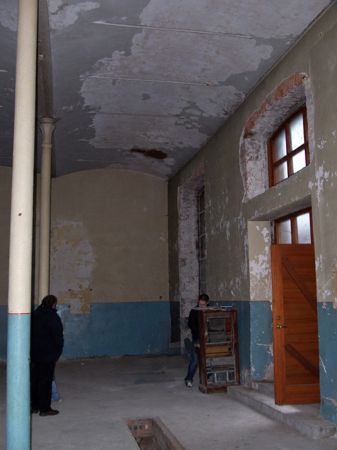 Engine room before renovation, showing the tall ceiling, original columns and exposed window openings.