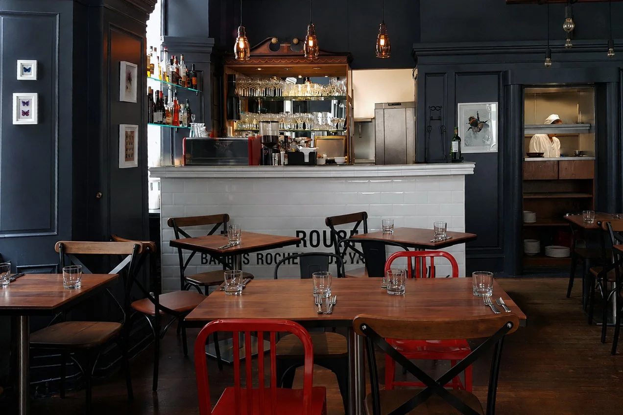 Cardo restaurant interior in Perth, with dark painted walls, timber tables and vintage chairs.