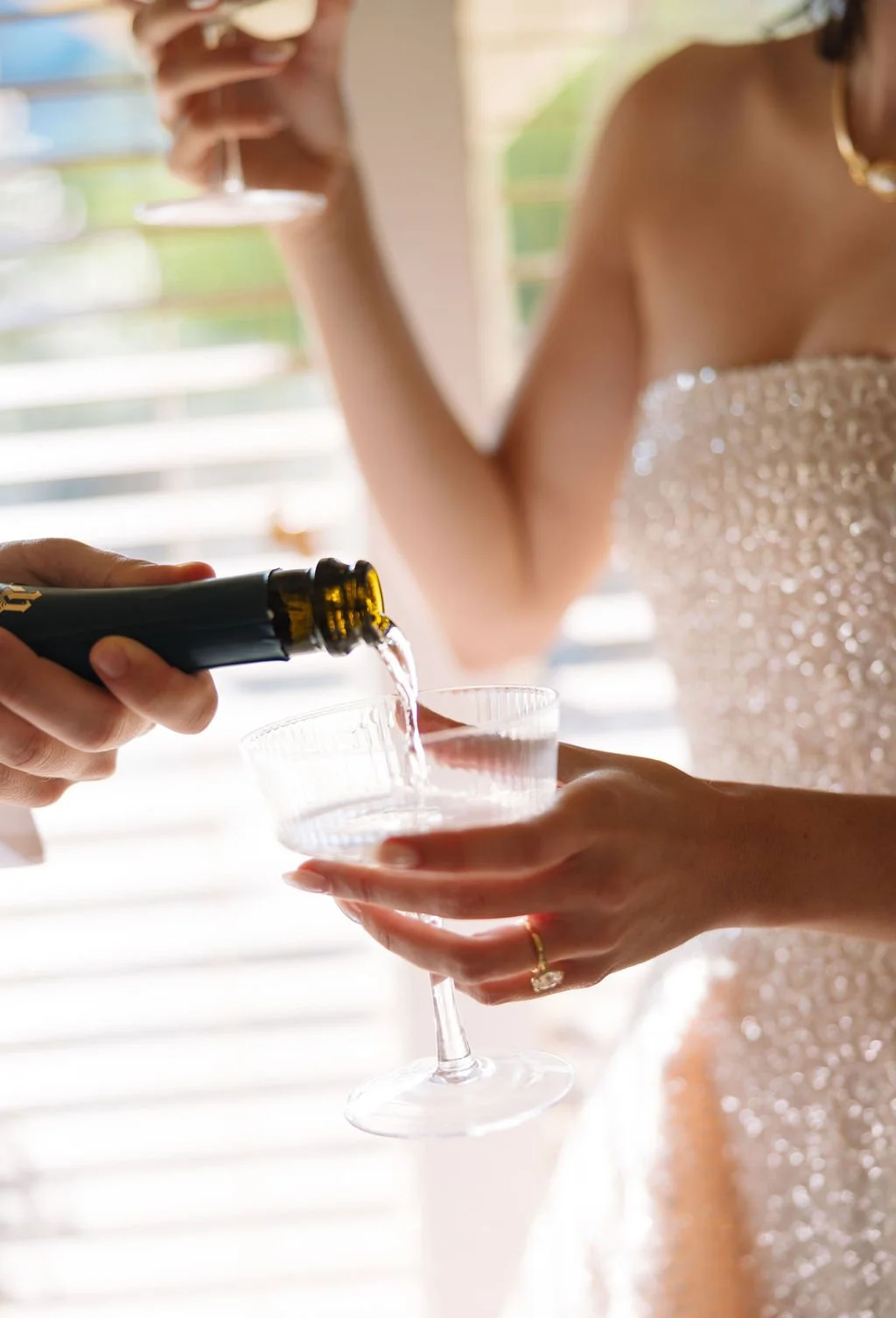 Close-up of champagne being poured into coupe glass inside Austin Motel suite