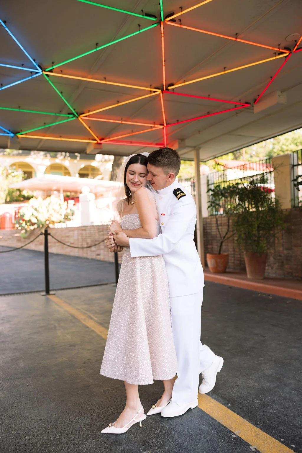 Couple embracing under the neon lights of the Austin Motel driveway