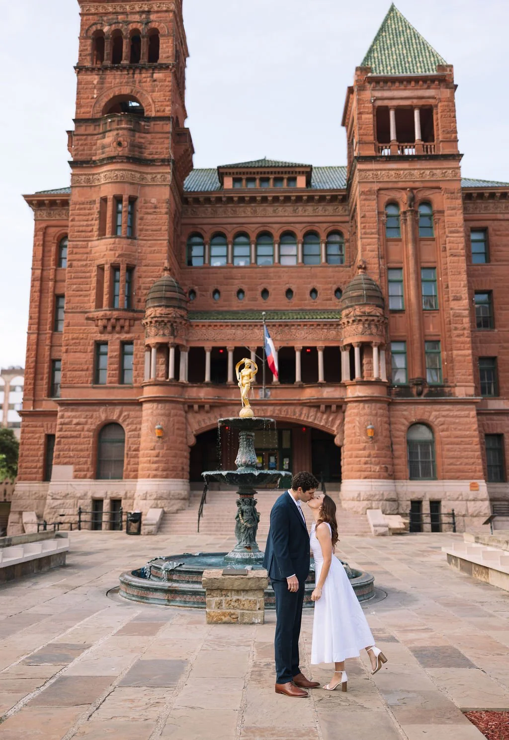 Couple standing in front of Bexar County Courthouse during engagement photos San Antonio.