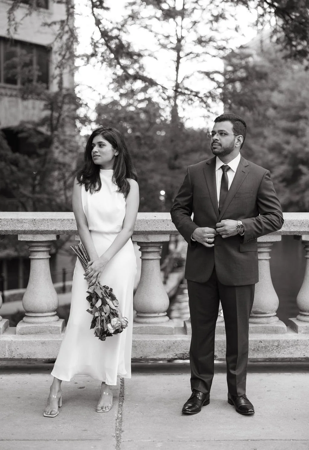Couple posing together by stone railing during San Antonio engagement session