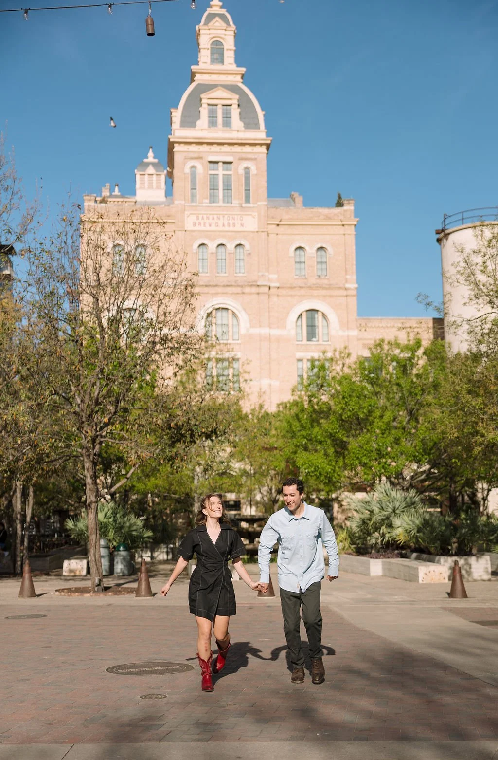 Couple frolicking in front of the Pearl during their San Antonio engagement photos