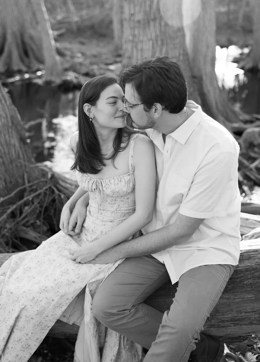 Couple kissing on tree log at Cibolo Nature Center engagement photos.