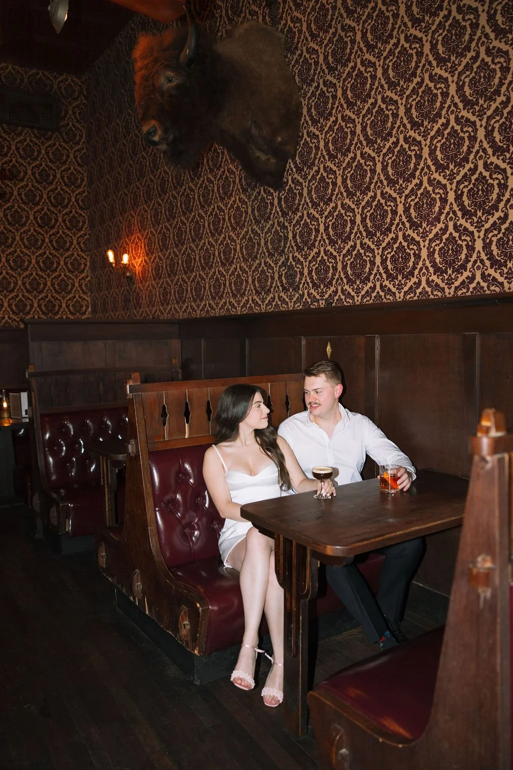 Couple sharing drinks in their booth at Esquire Tavern