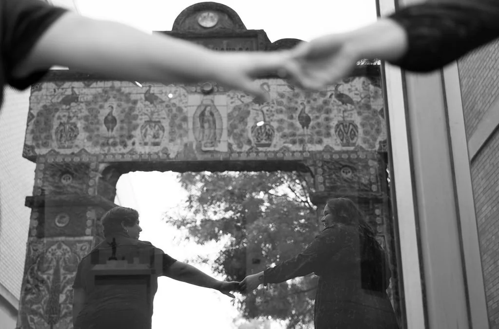 Close-up of couple holding hands across table in black and white during San Antonio engagement photos.