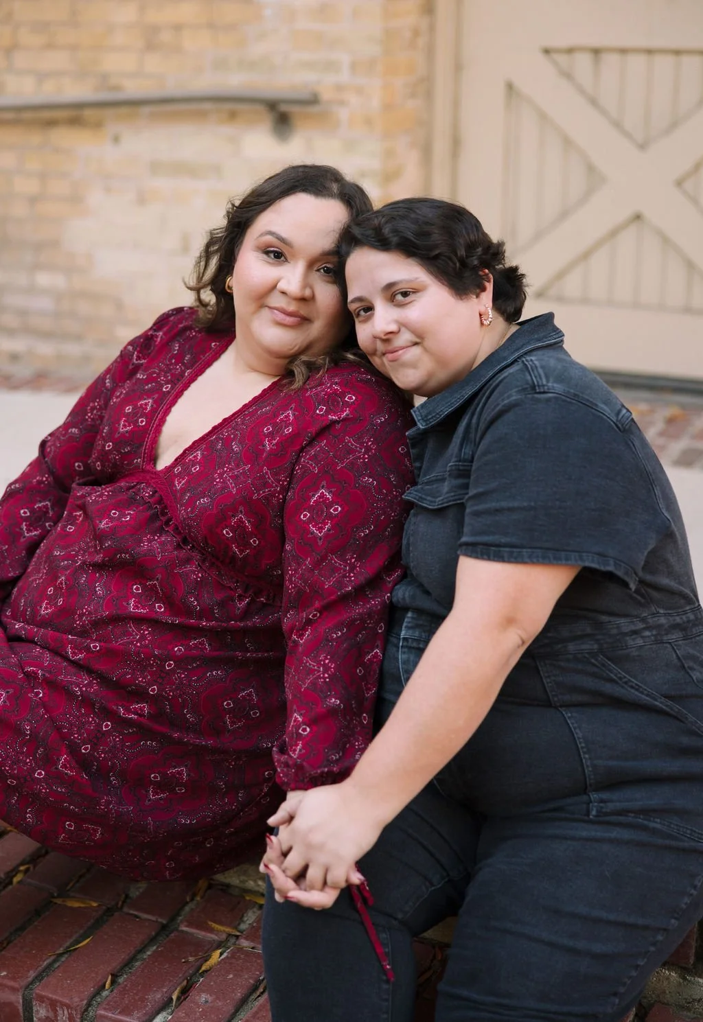 Couple sitting on brick steps together during San Antonio Museum of Art engagement photos.