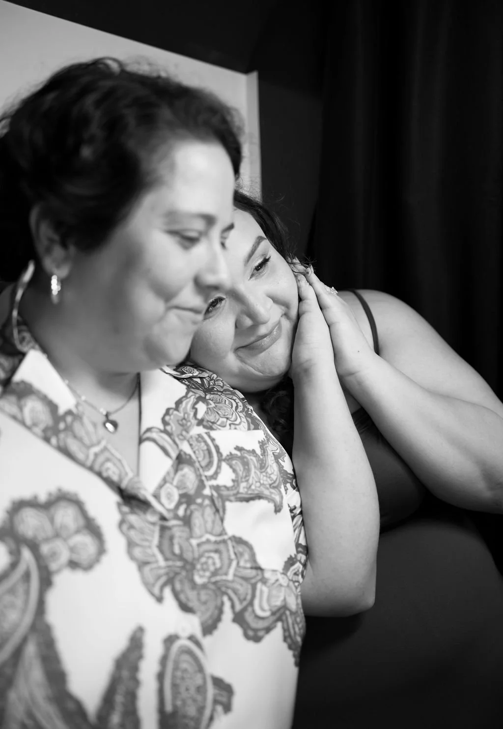 Couple cuddling closely in black and white at Idle Beer Hall during San Antonio engagement photos.