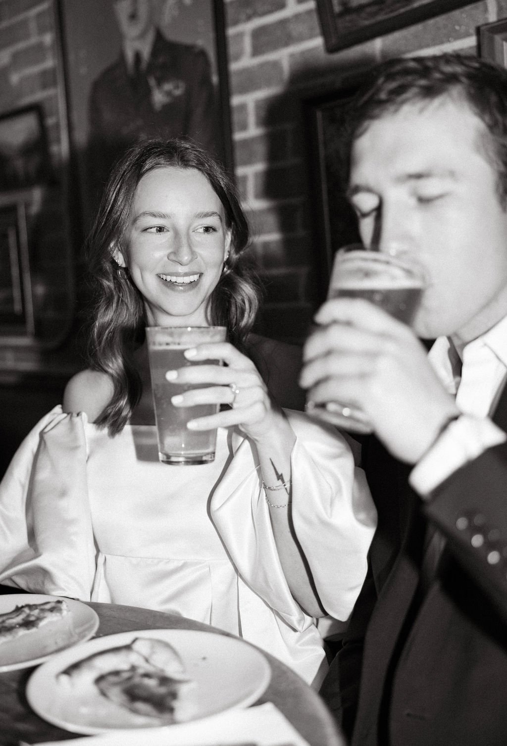 Couple smiling and drinking beer in black and white during Barbaro engagement photos San Antonio.