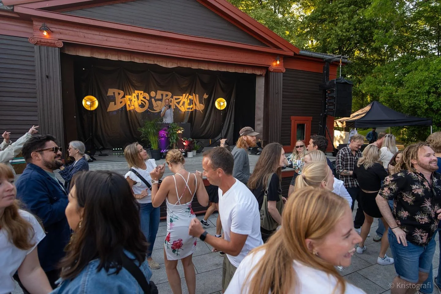 Folk danser foran en utendørs scene med et band som spiller, og et banner med navnet "Beats Bergen" i bakgrunnen.