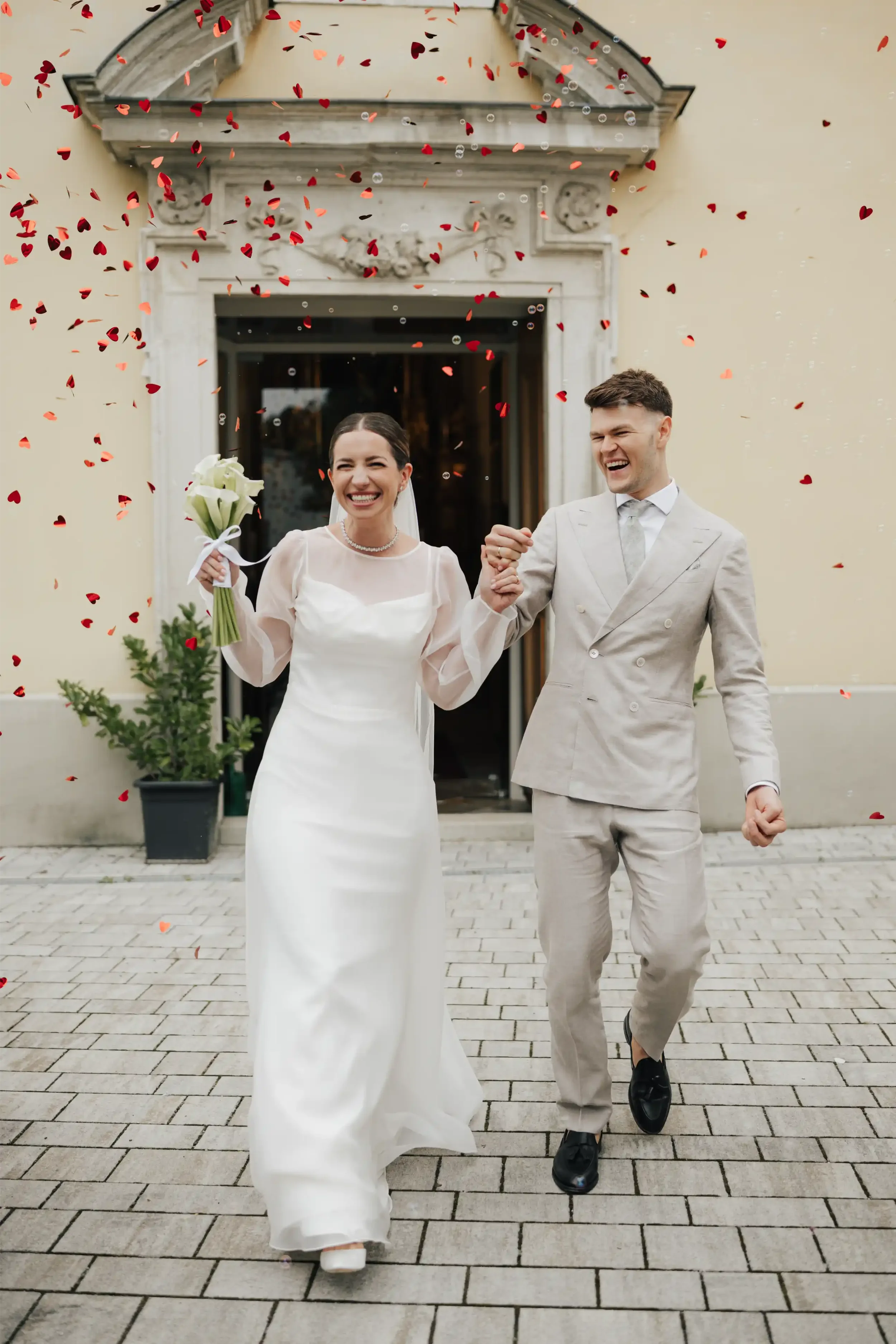 Newlyweds walking hand in hand out of a church