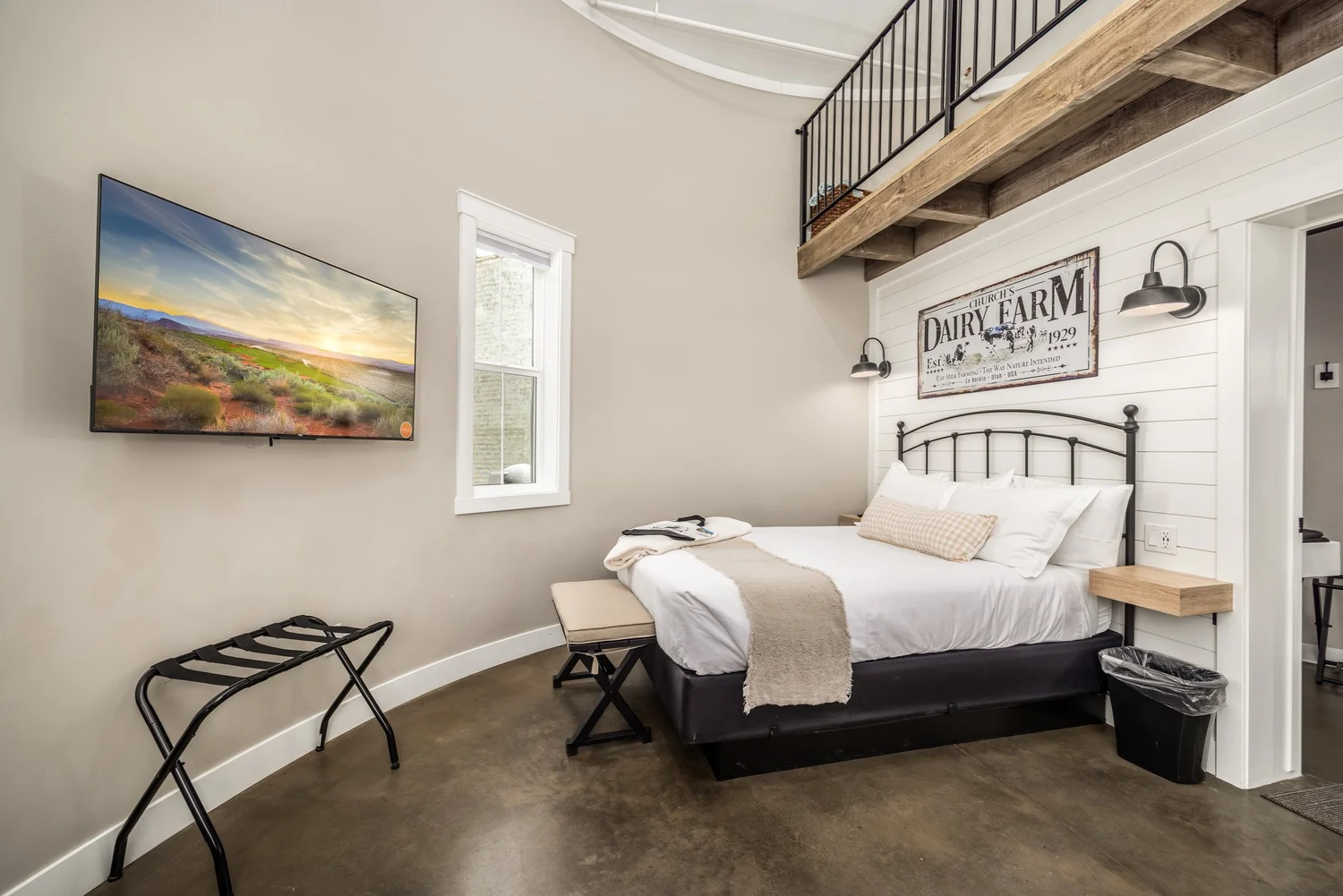 Rustic bedroom beneath a loft railing — from Sam Reed’s photography portfolio
