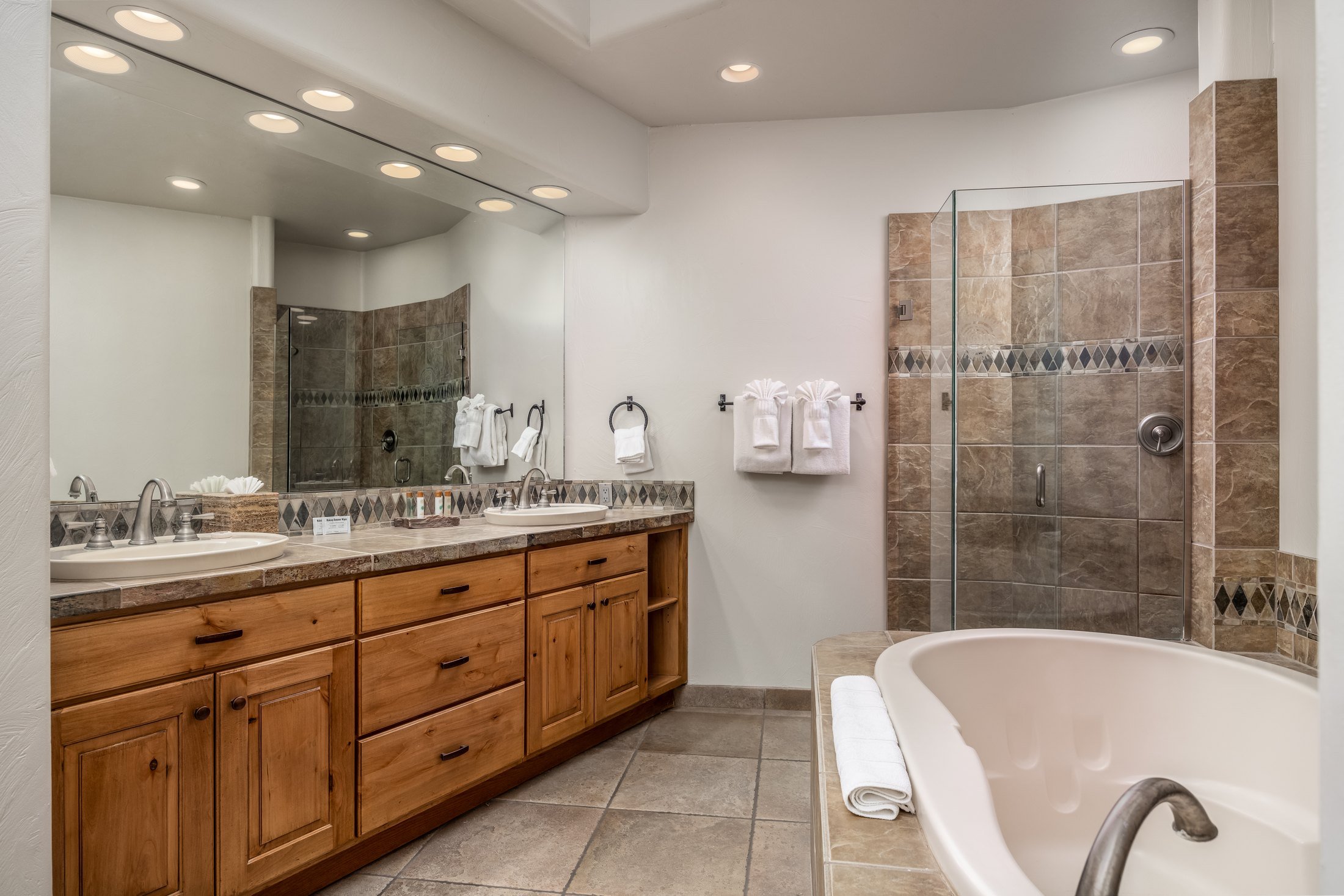 Guest bathroom with a wood vanity and freestanding bathtub at The Inn at Entrada