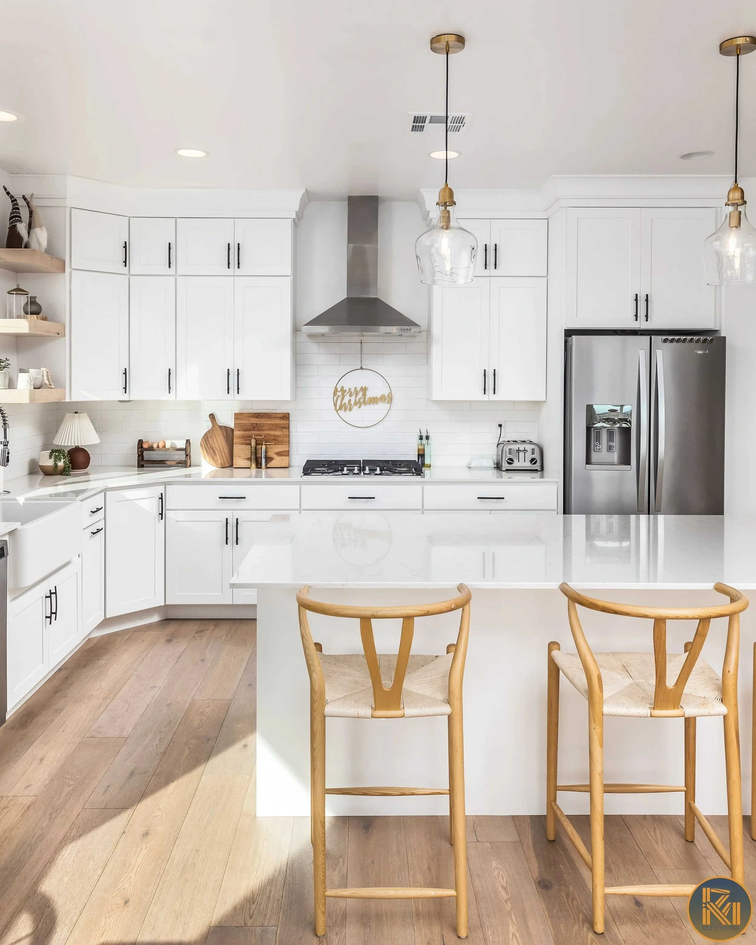 Bright white kitchen with a central island, photographed by Sam Reed