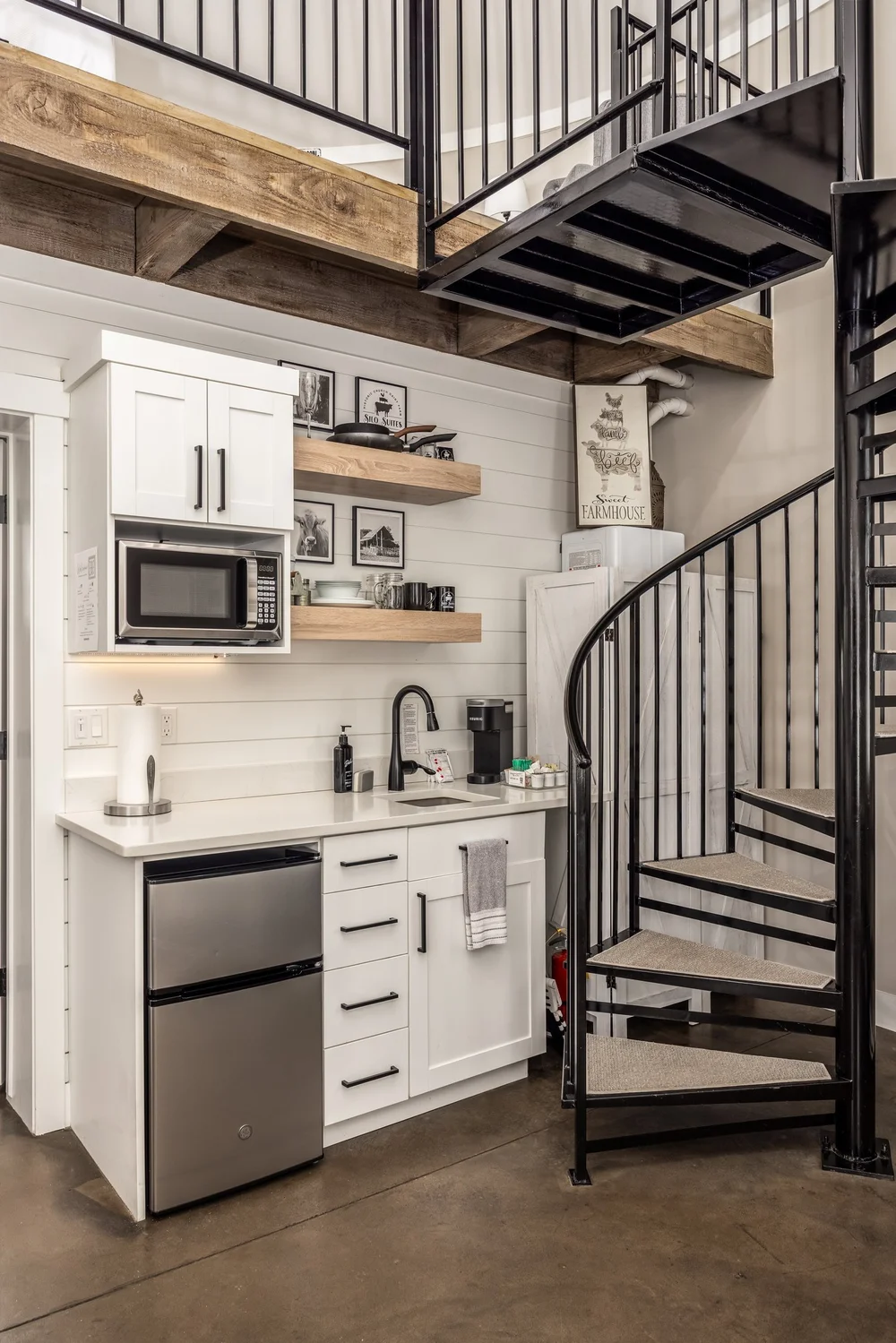 Compact kitchenette beneath a loft staircase at The Silo Suites