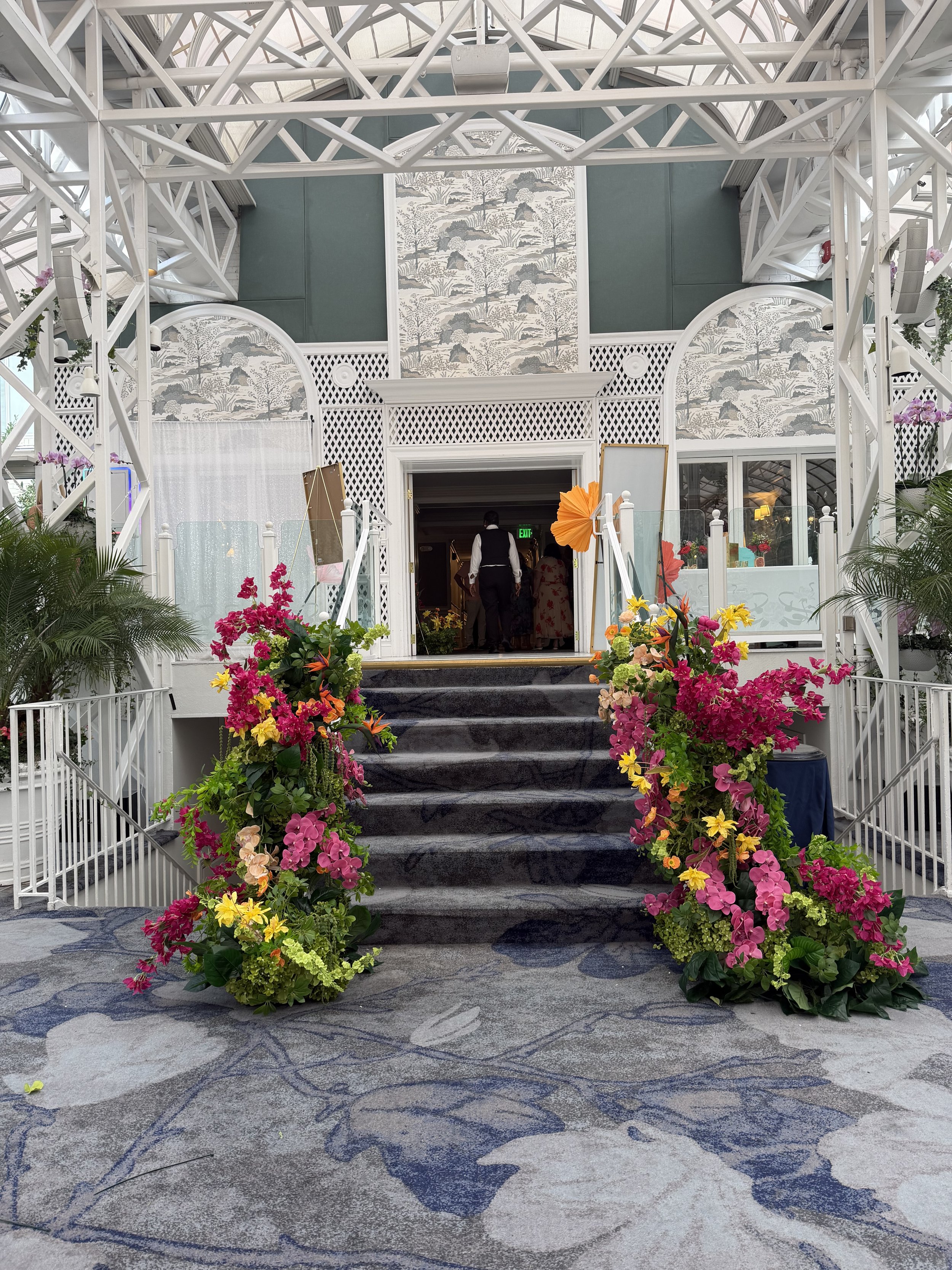 Conservatory staircase at The Madison Hotel wrapped in pink, magenta and green fresh flowers by Blooms by Lily, floral stair wrap designer in New Jersey