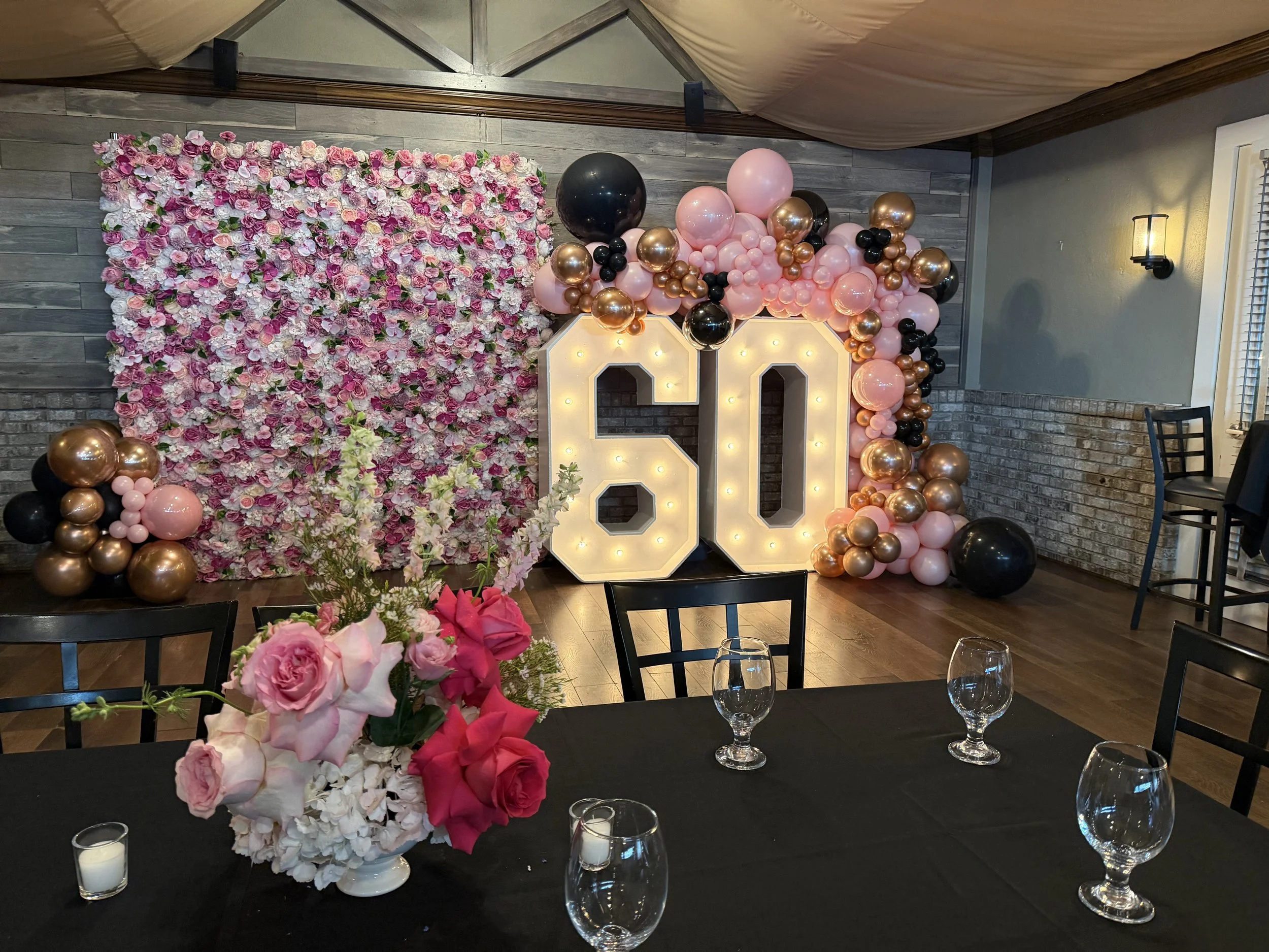 Pink rose flower wall with marquee 60 letters and pink and red centerpieces on black linens for Carla’s 60th birthday in New Jersey, by Blooms by Lily