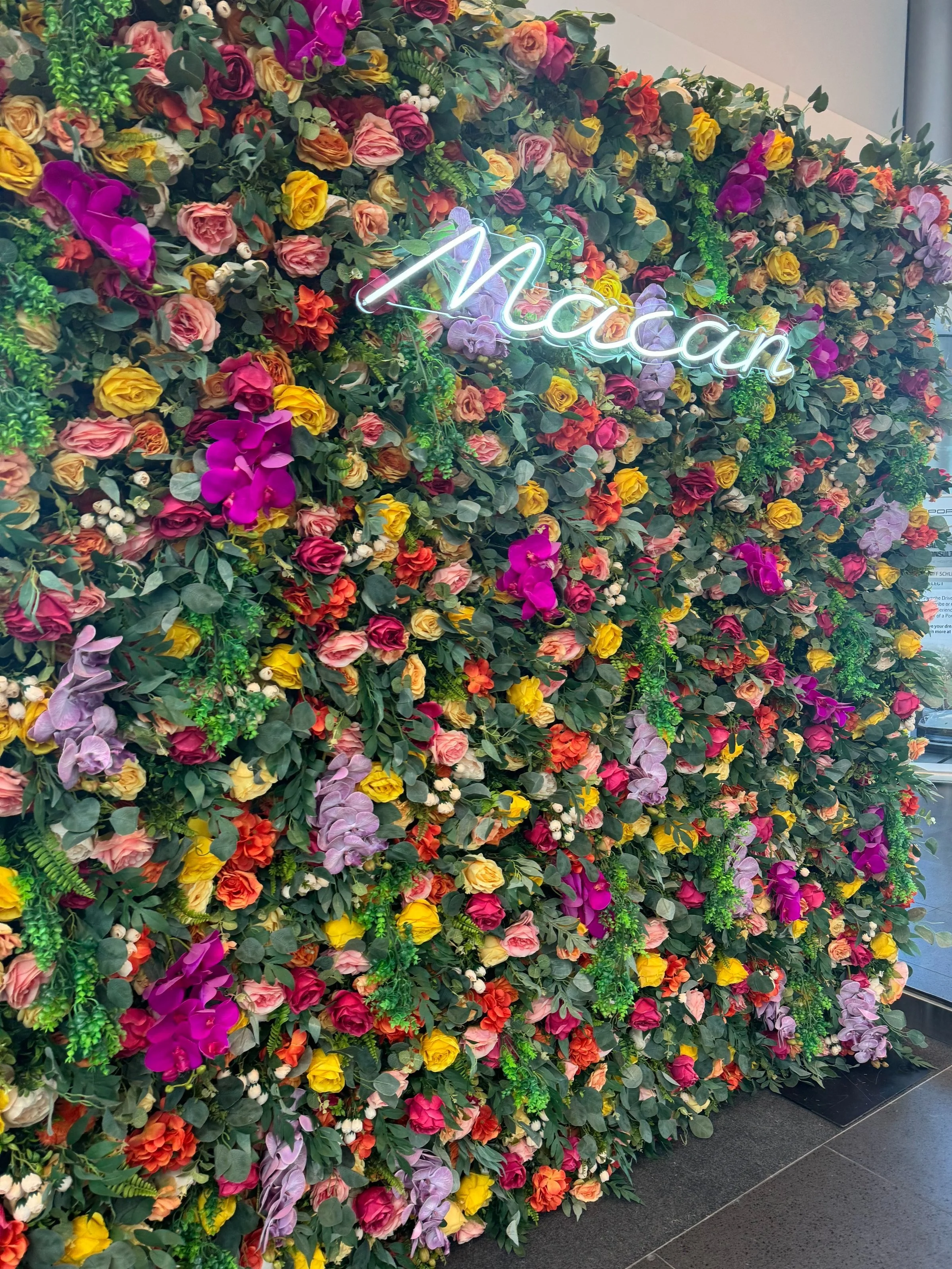 Sady colorful flower wall with orchids, roses and a neon sign, by Blooms by Lily
