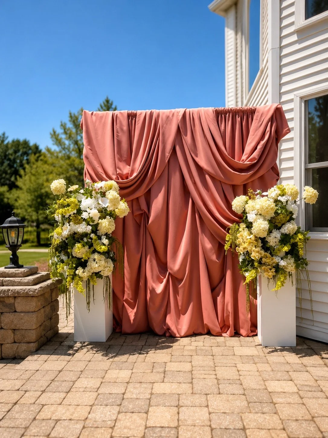 draped mauve wall and green florals bridal shower backdrop 