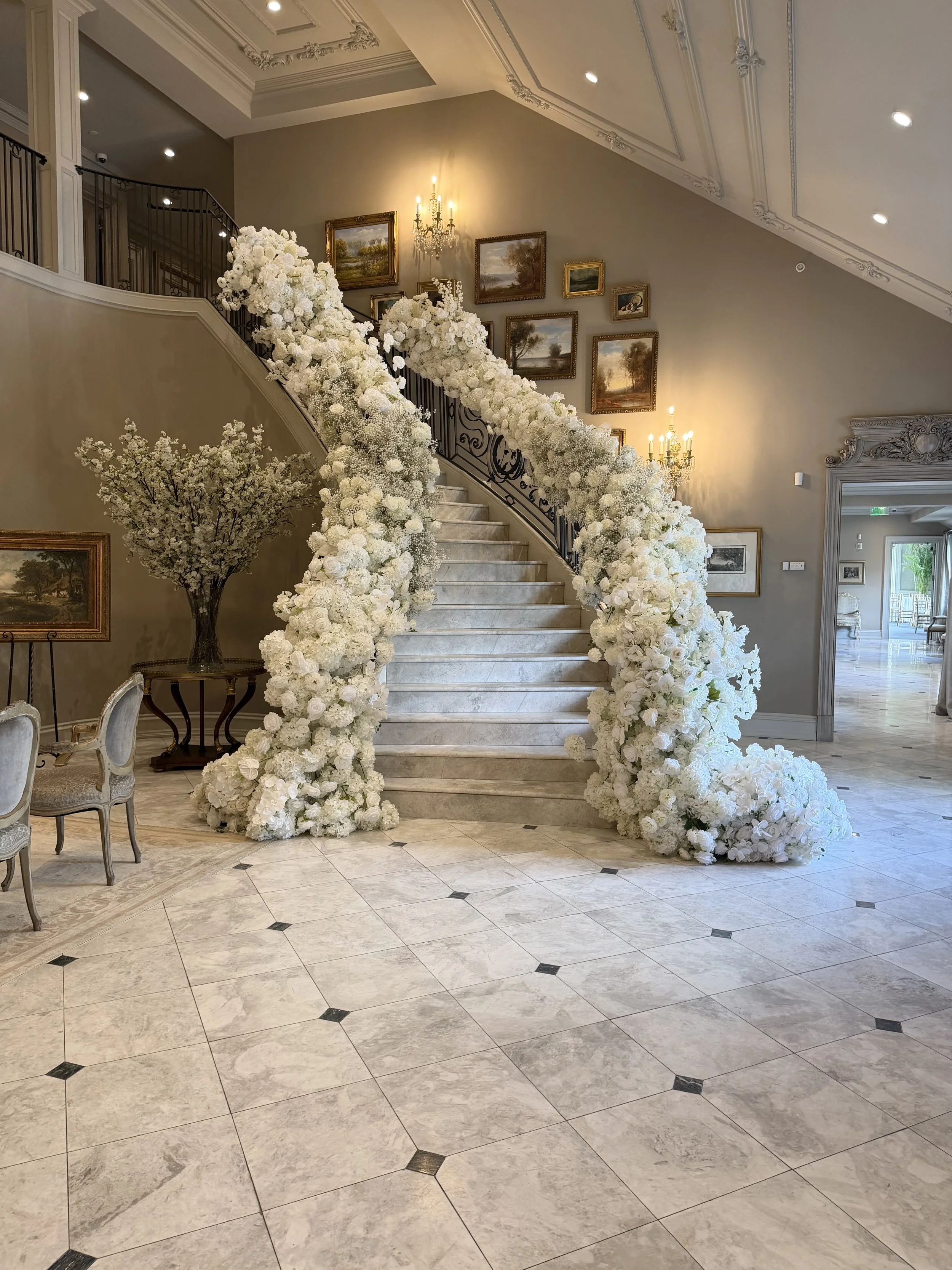 Grand staircase dressed in white florals, by Blooms by Lily