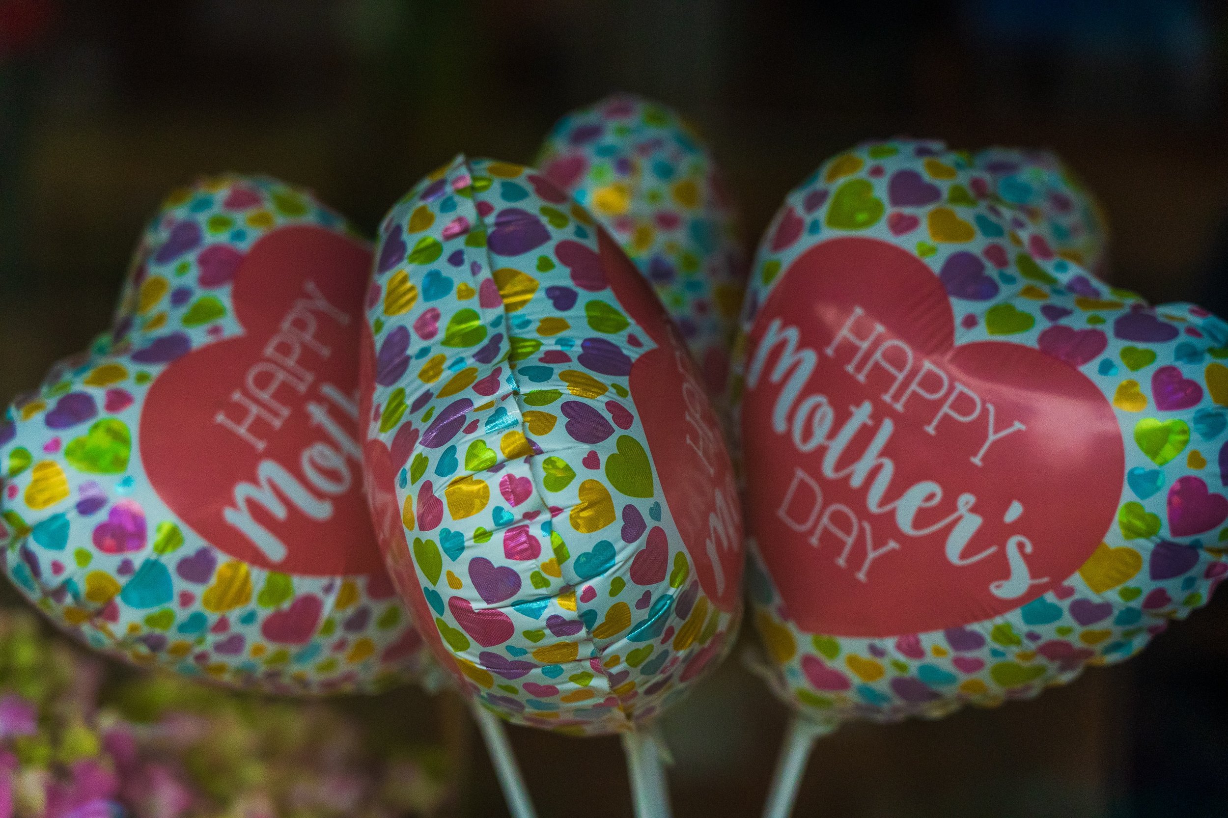 Heart-shaped balloons with colorful heart patterns and "Happy Mother's Day" message.