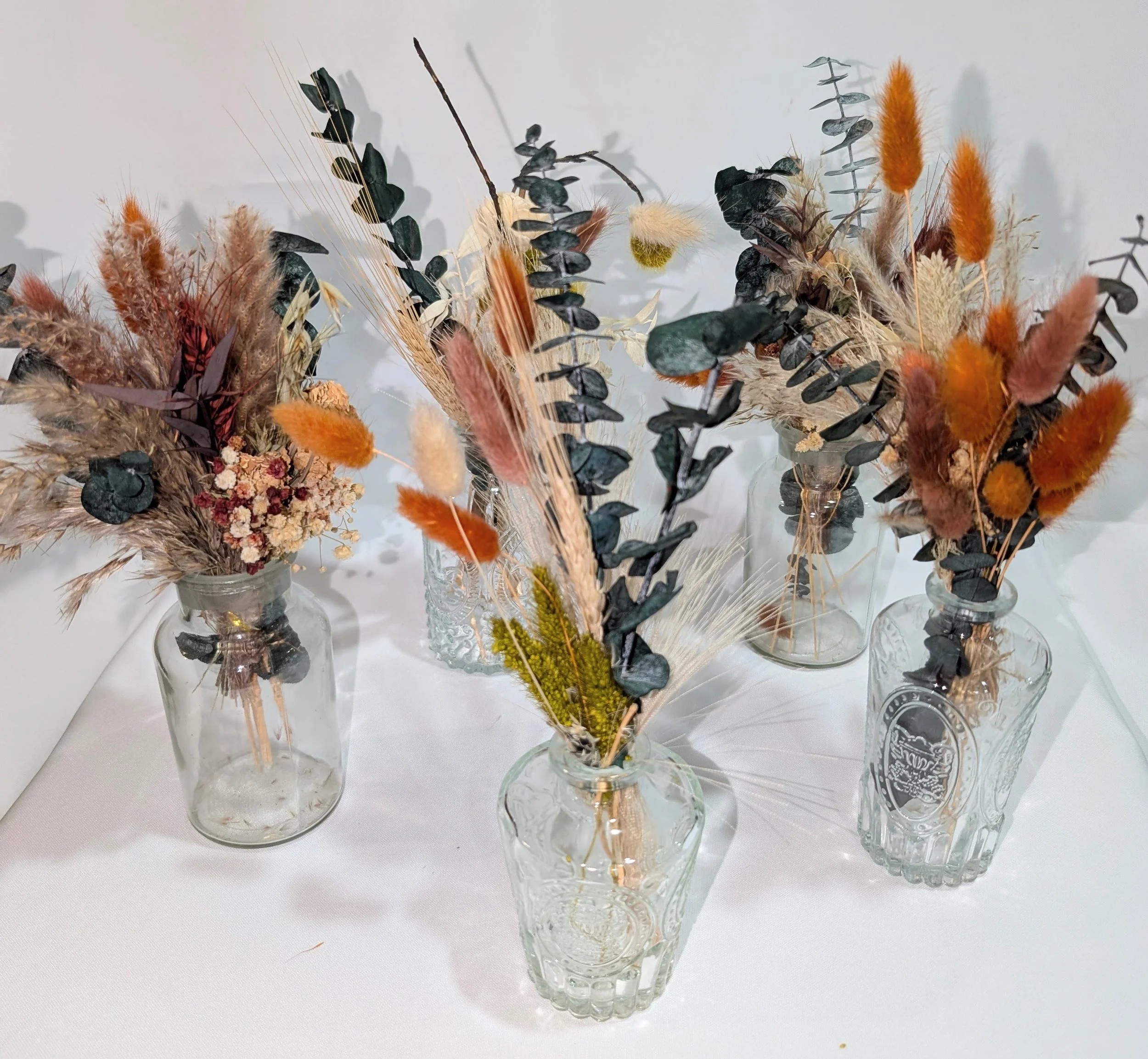 Dried arrangments in small assorted shape glass vases, qty 5.