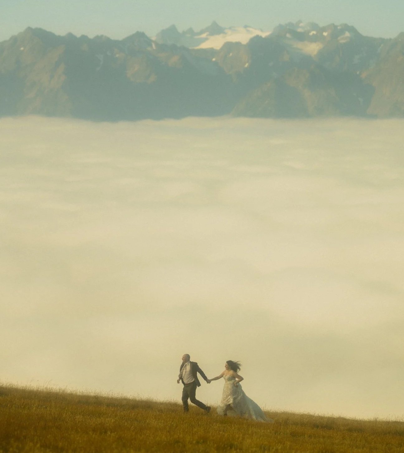 elopement couple running along mountain ridge in Hurricane Ridge of Olympic National Park