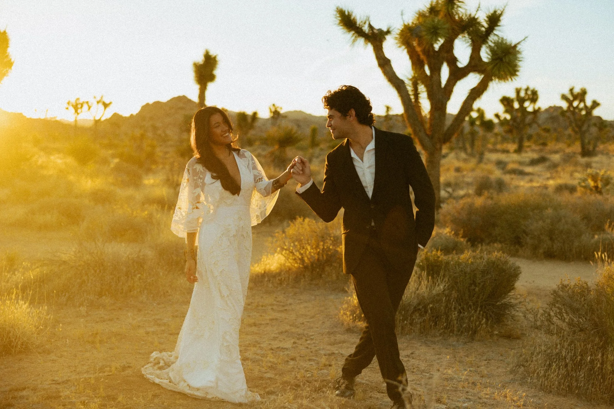 elopement couple walking among Joshua Trees at Sunset