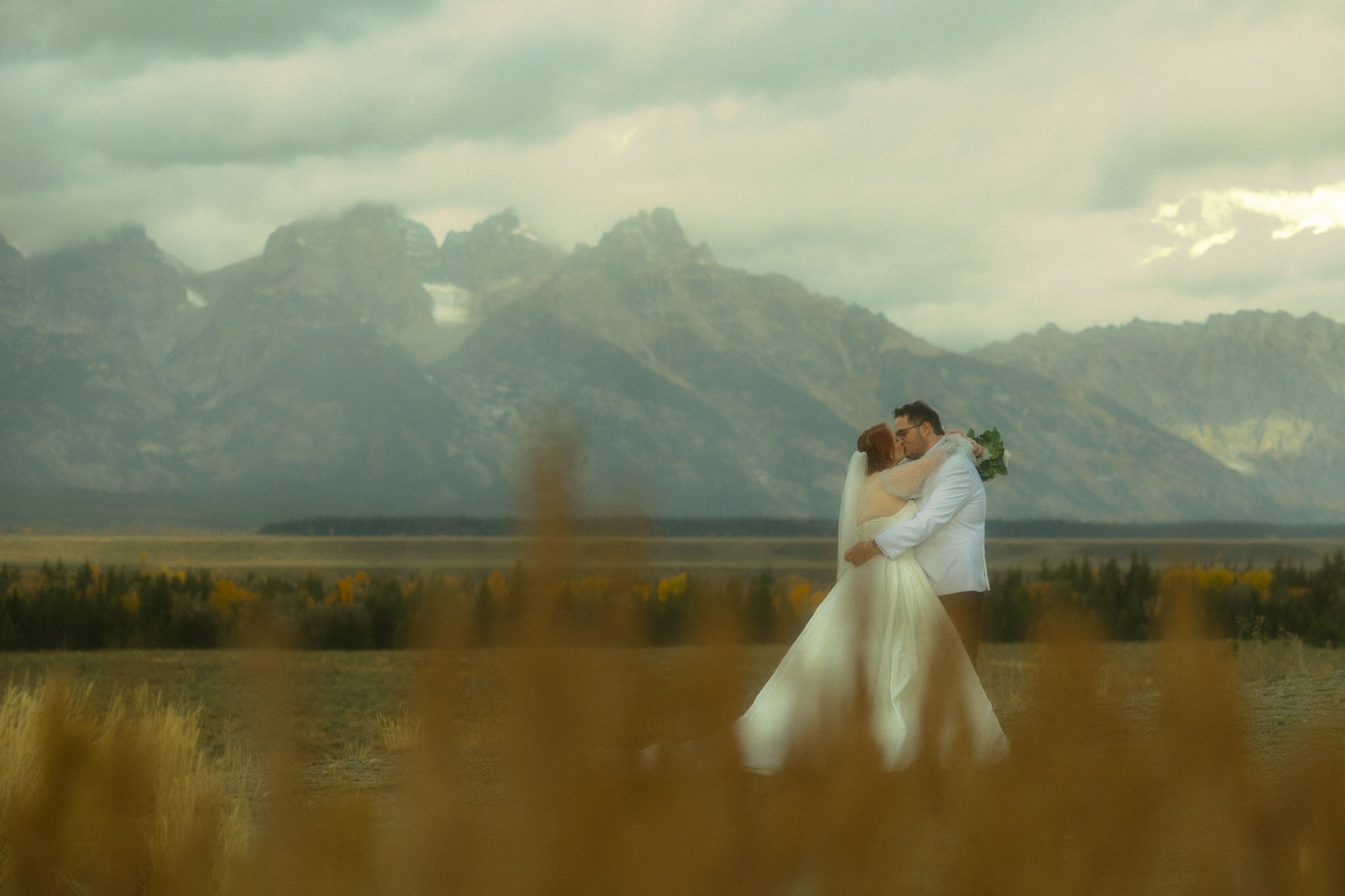 an elopement couple kissing at Glacier View Turnout in Grand Teton National Park