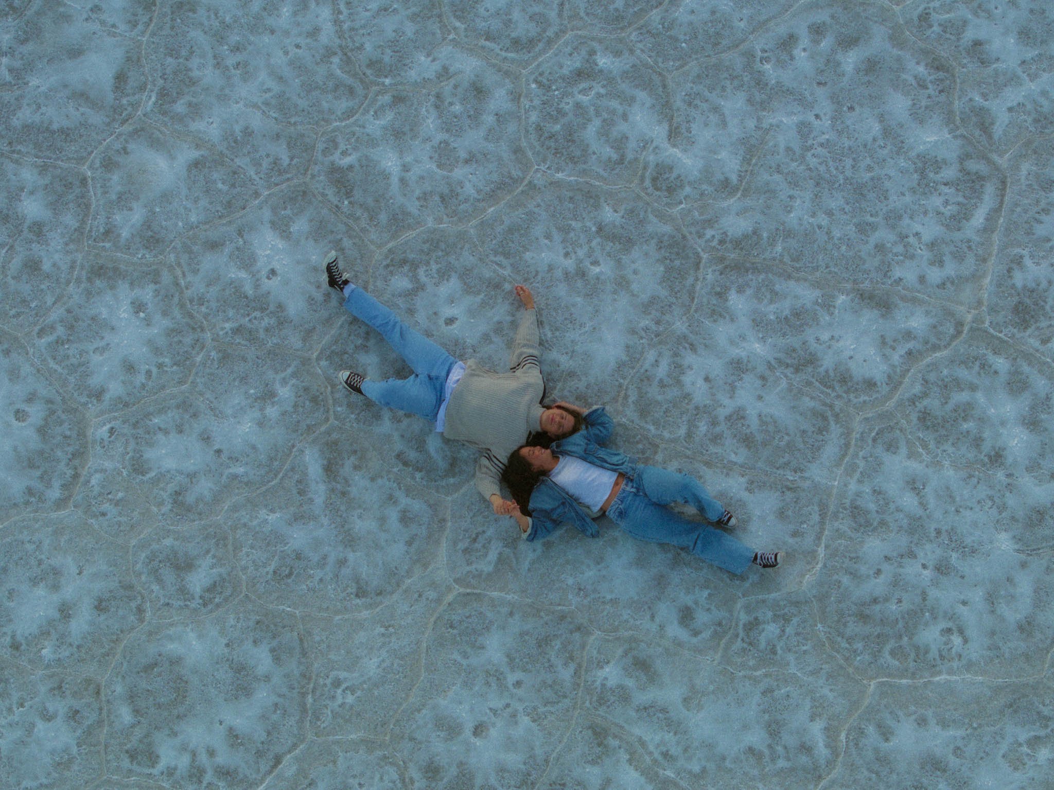 A couple laying down on the Salt Flats in Utah