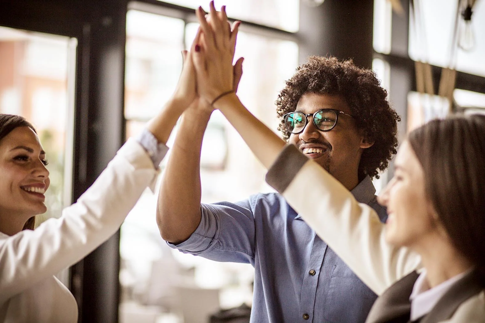three coworkers high-fiving