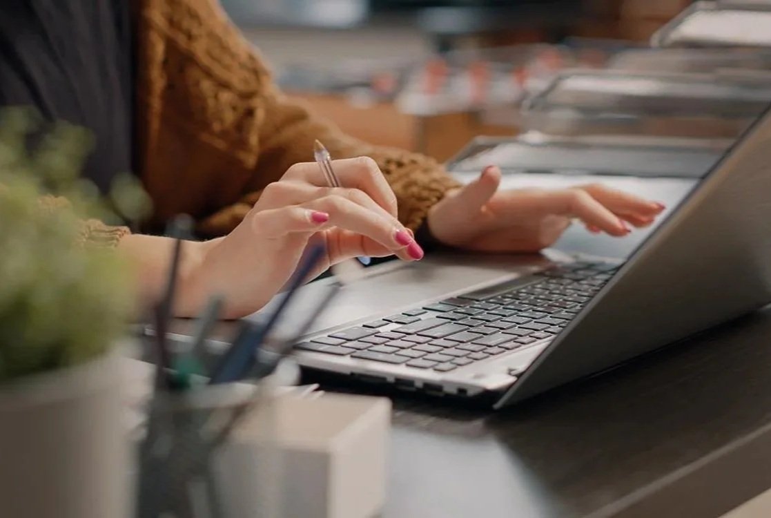 Team member typing on computer in shared office space.
