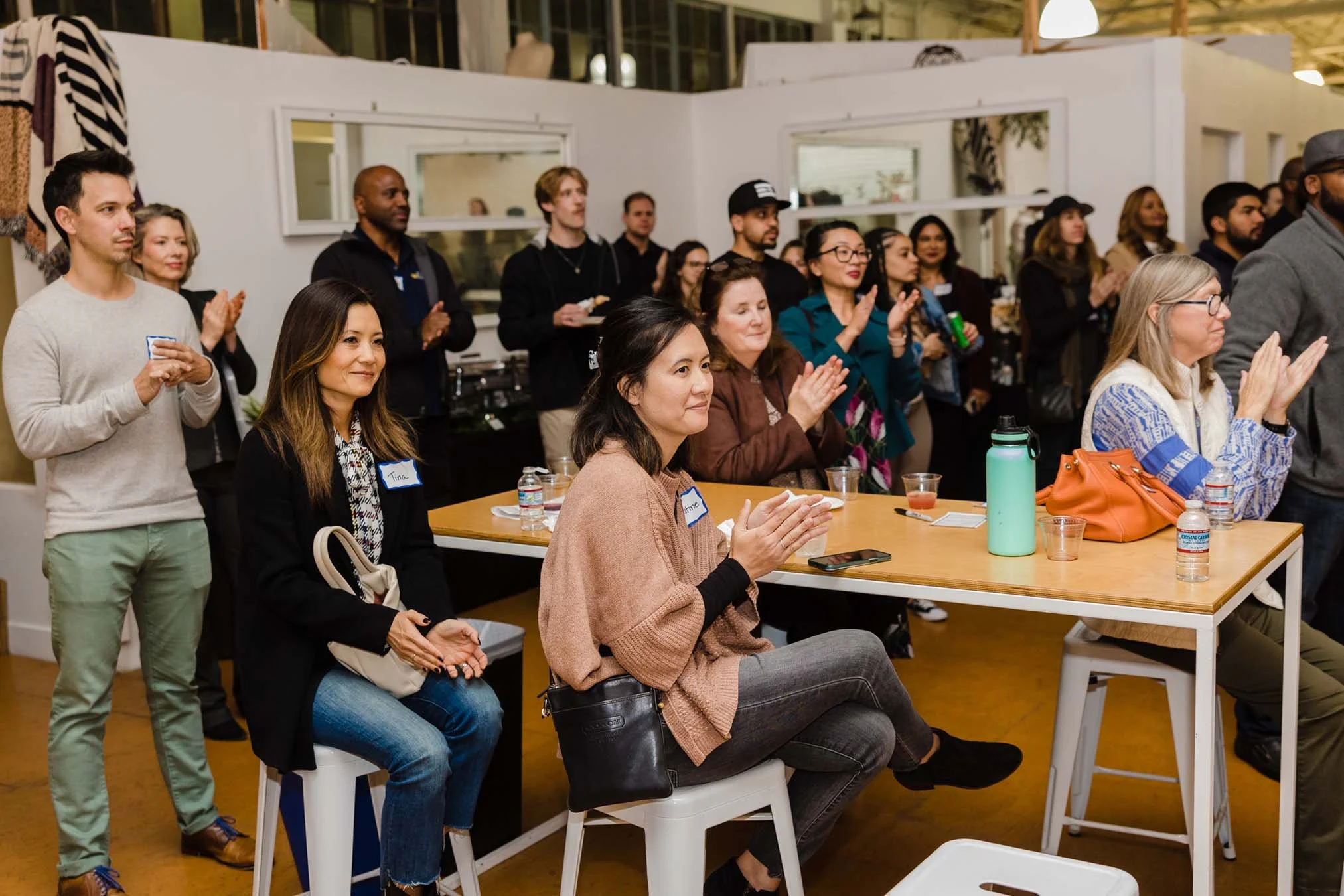 crowd of impact lab participants and supporters clapping for presenters at networking event celebrating small business growth