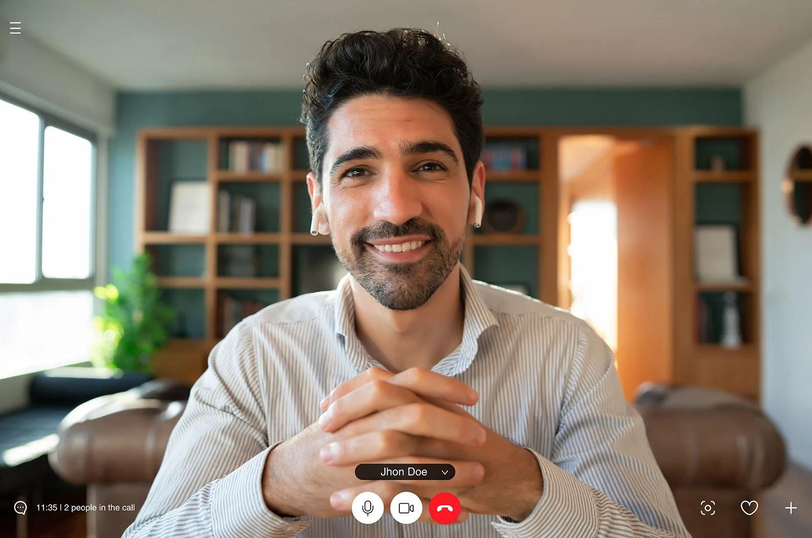 man in stripped button up shirt smiling on a virtual call interview