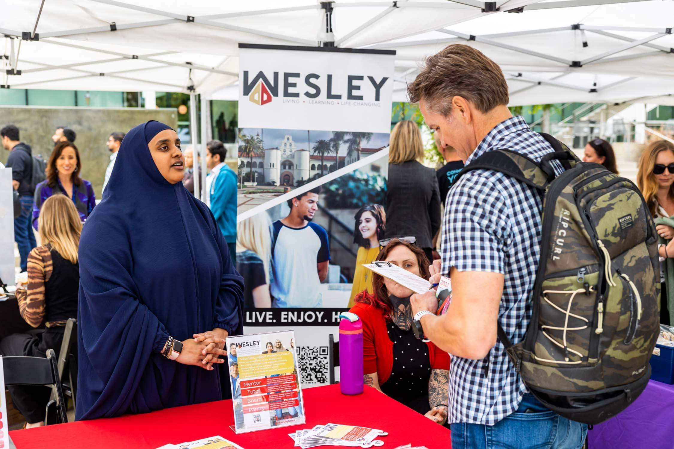 man-speaking-with-nonprofit-group-at-their-booth.jpg