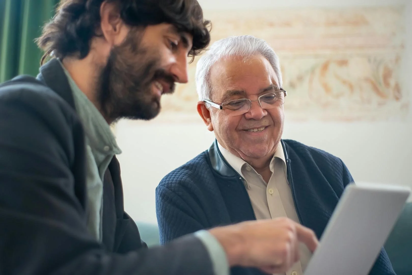 two men reviewing printed nonprofit accounting report together and smiling
