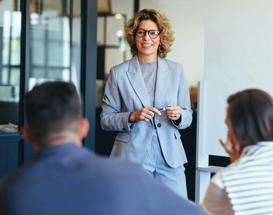 new nonprofit leader confidently standing in front of team in a meeting room