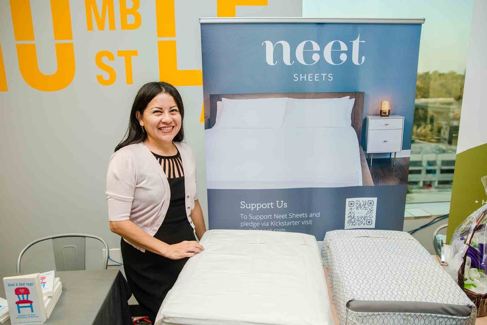 small-business-owner-standing-next-to-her-bed-sheet-business-product-samples.jpg