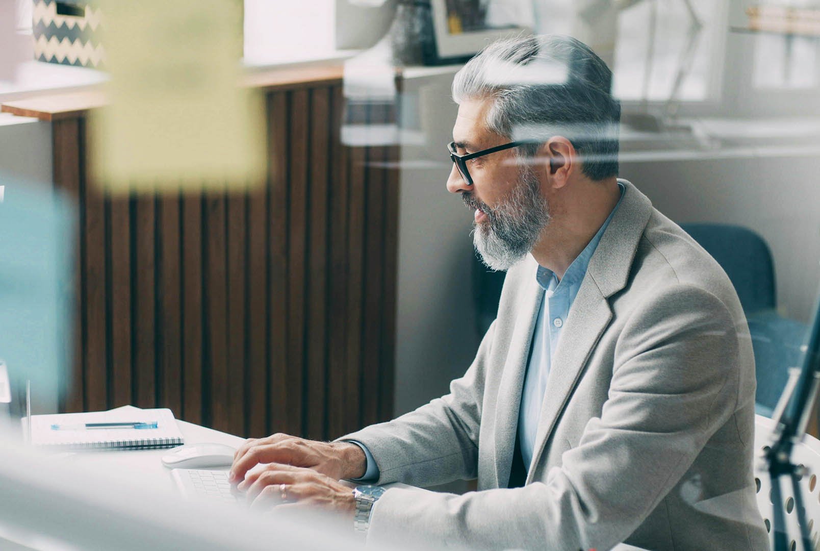 nonprofit executive director busy working at desk in office with sticky notes on his window