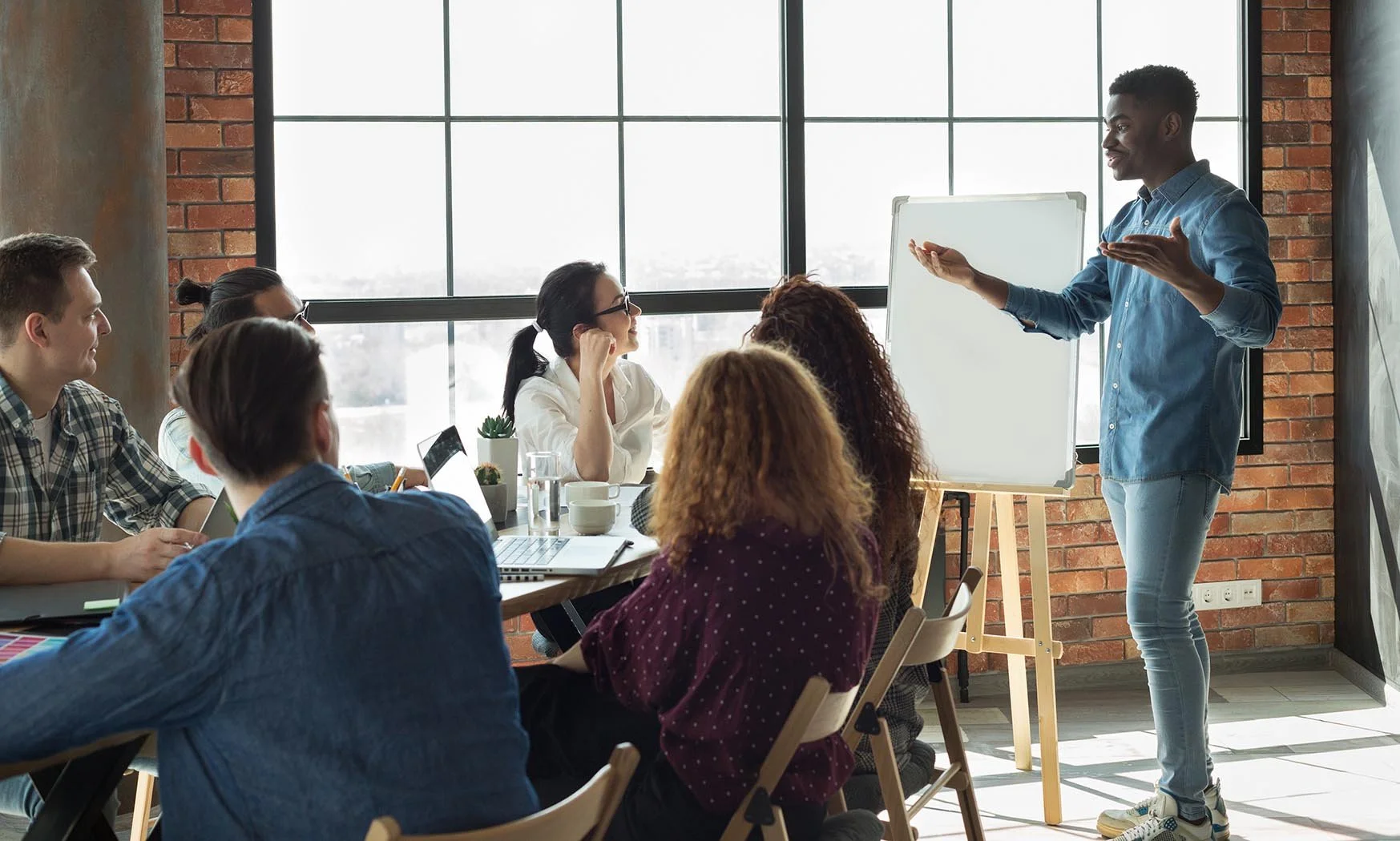 young nonprofit team member enthusiastically giving presentation to an encouraging group