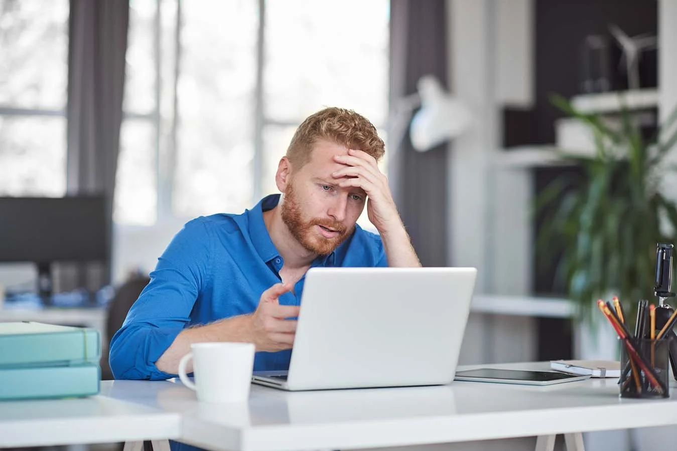 man working on accounting report on his laptop and struggling to understand it