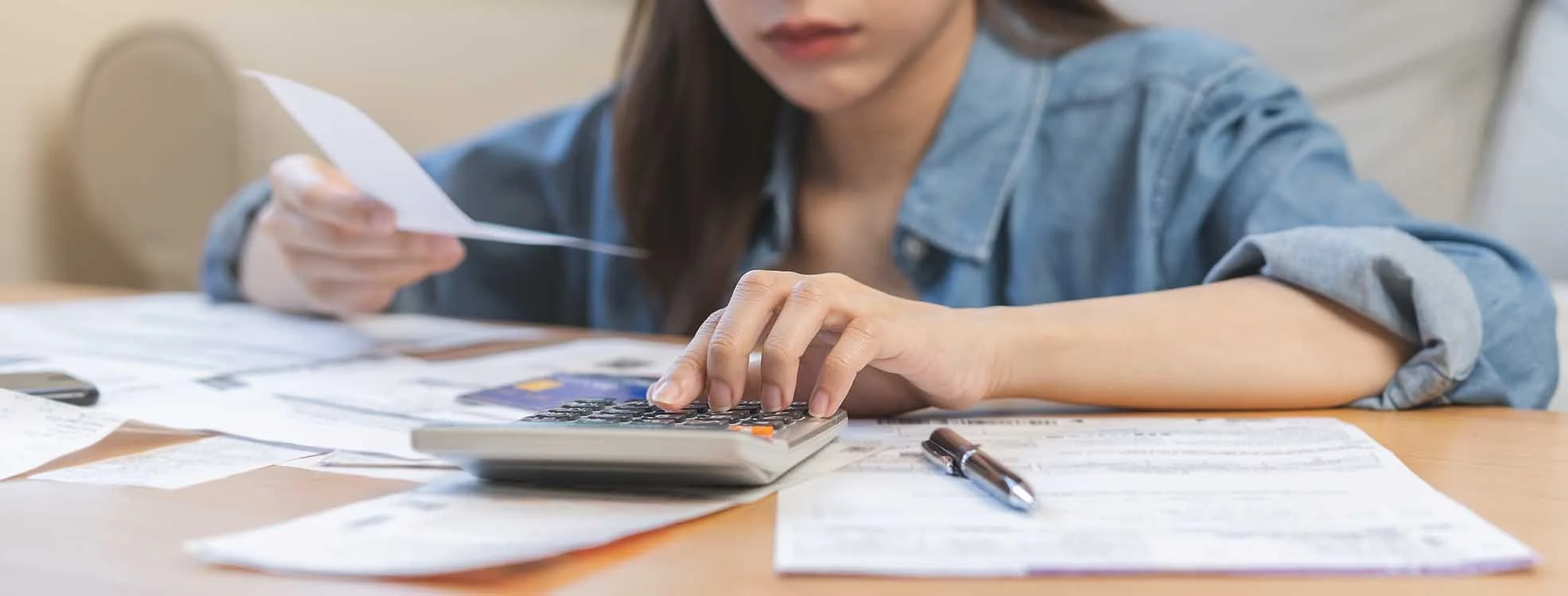 woman sifting through nonprofit receipts and making calculations on her calculator