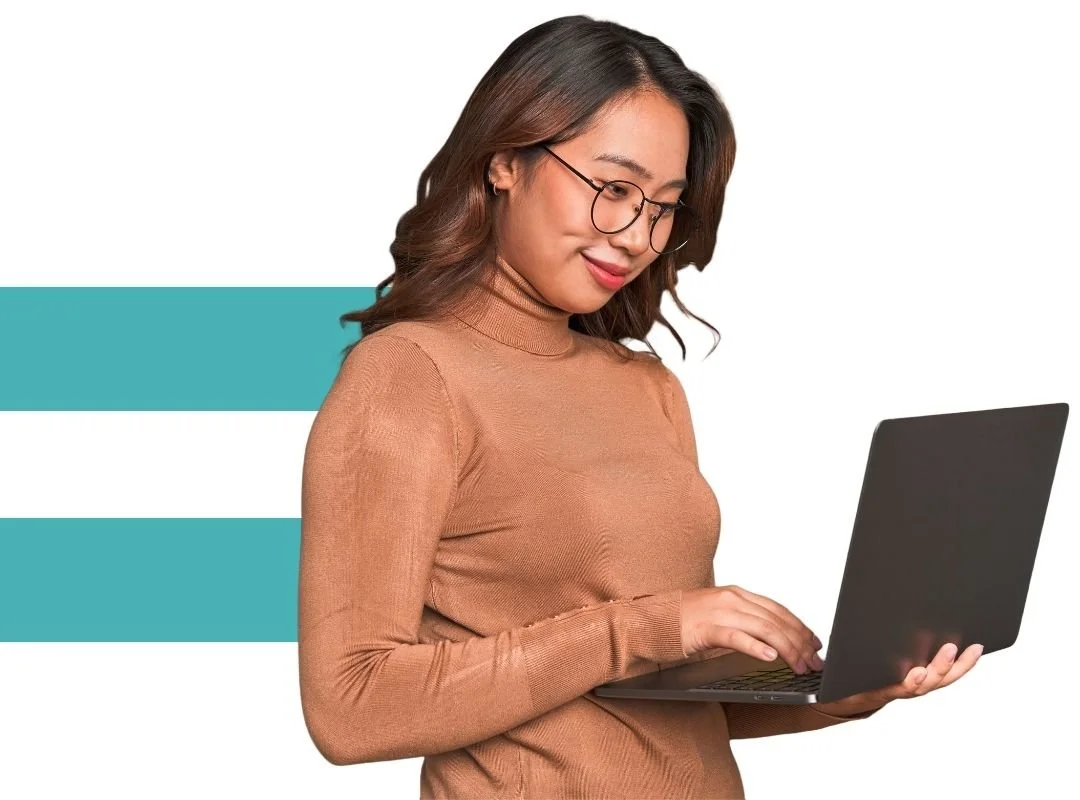 Female nonprofit accountant in brown sweater standing while working on laptop.