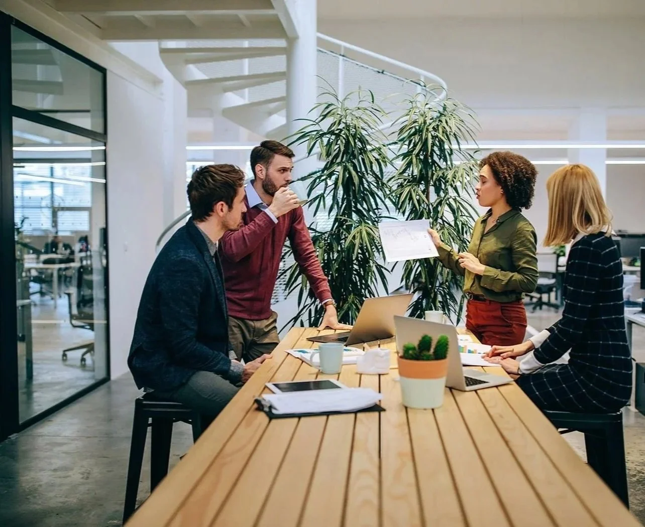 HR manager having a meeting with nonprofit team and holding up a piece of paper with a graph on it