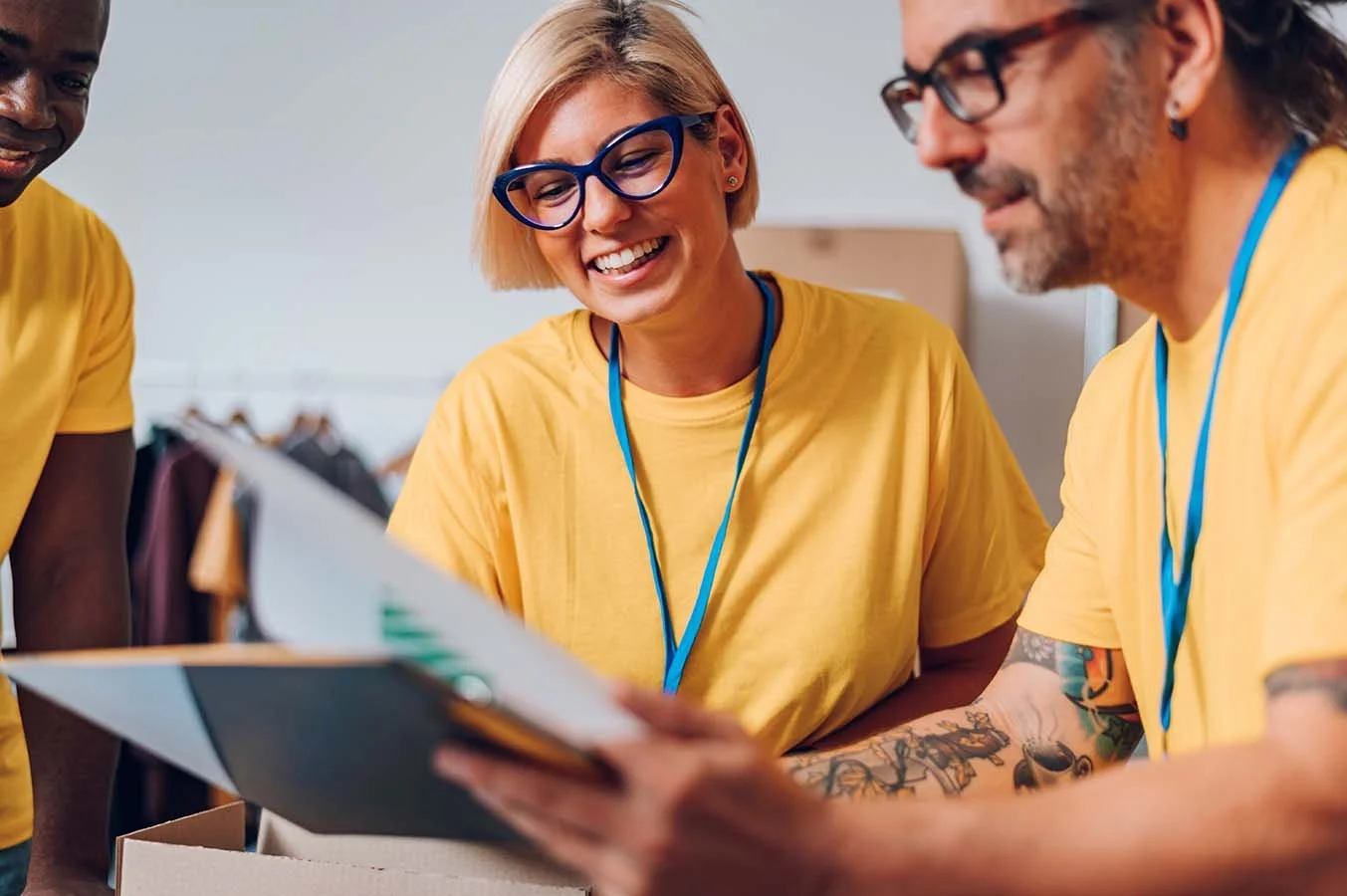 volunteers in yellow t-shirts at a charitable event going over paperwork together